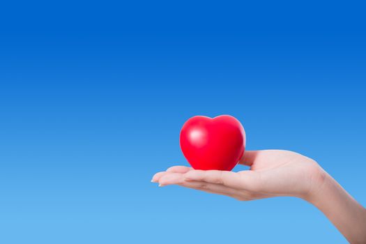 Heart in the hand on sky background with hope and charity concept.