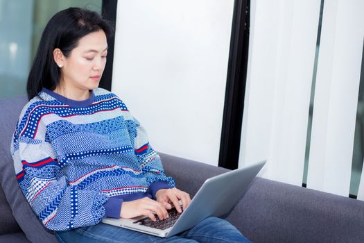 Closeup computer notebook on sofa with asian woman for work in lifestyle of woman concept