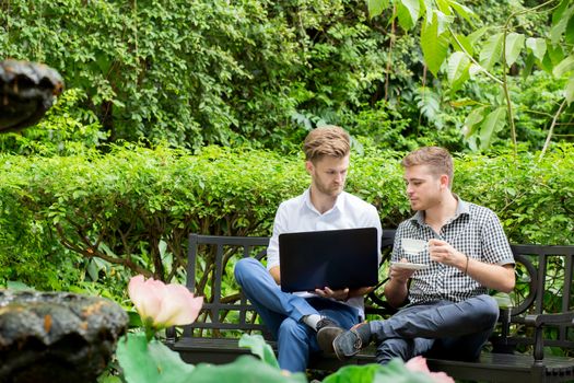 Two business people use of the notebook computer at outdoor