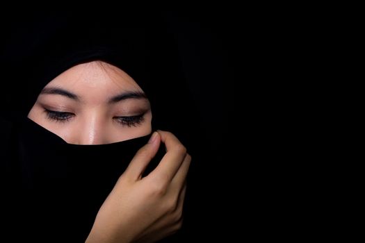 beautiful mysterious young woman wearing scarf close up.