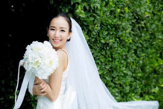 beautiful young woman on wedding day in white dress in the tree wall. Female portrait in the park - Selective focus.
