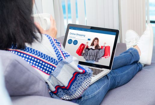 young woman on sofa shopping online with notebook in living room.
