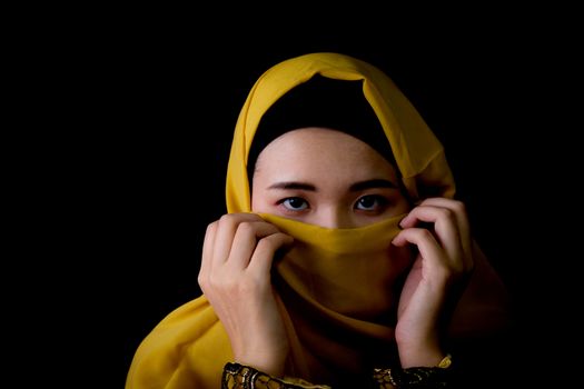 beautiful mysterious young woman wearing scarf close up.