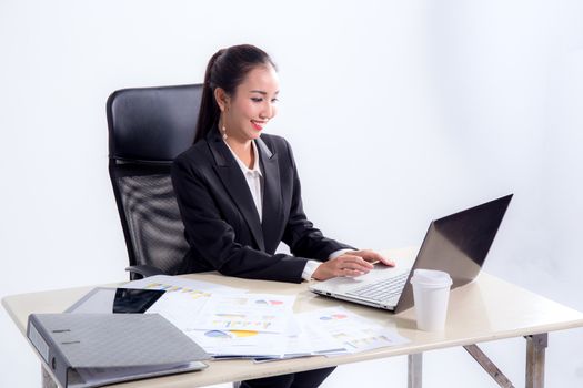 Young businesswoman working in office, typing, using computer. Concentrated woman searching information online