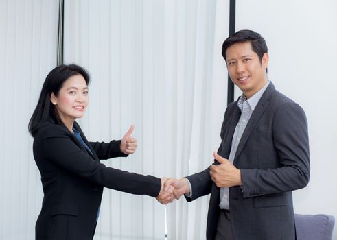 Handshake of businessman and businesswoman after successful business meeting.