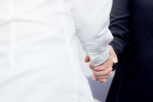 Handshake of businessman and businesswoman after successful business meeting.