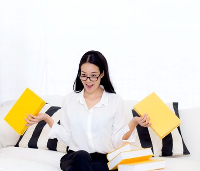 portrait of a beautiful young female student with not want read book on sofa in living room - education concept.