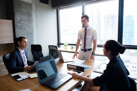 Businesspeople with leader discussing together in conference room during meeting at office.