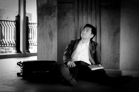Stressed asian businessman bankrupt with sitting at outdoor.