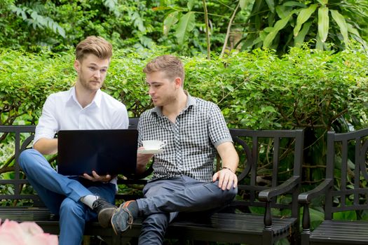 Two business people use of the notebook computer at outdoor