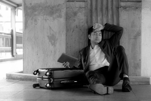 Stressed asian businessman bankrupt with sitting at outdoor.