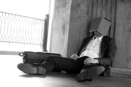 Stressed asian businessman bankrupt with sitting at outdoor and book close face.