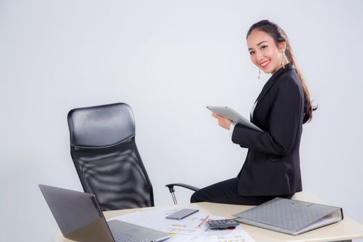 businesswoman looking tablet with sitting table in office on white background.