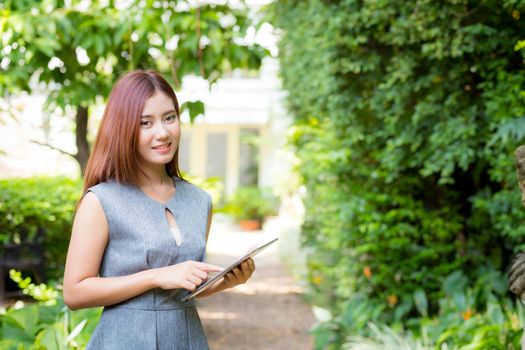 business woman in the garden looking tablet - happy and smiling.