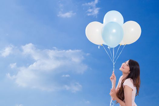 Young woman holding balloons i\on sky background lifestyle concept.