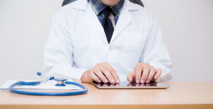 male doctor with tablet computer and stethoscope at the desk on white background.male doctor with tablet computer and stethoscope at the desk on white background.