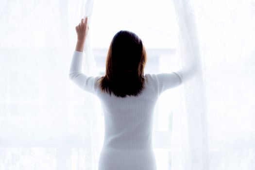 woman and hope concept - woman opening window curtains business concept.