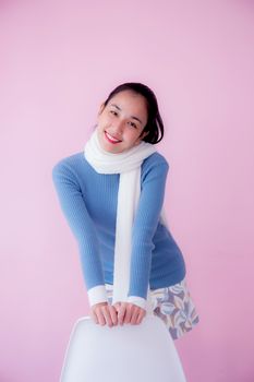 Happy beautiful young woman asian wearing scarf sitting on living room pastel color tone.