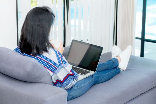 Closeup computer notebook on sofa with asian woman for work in lifestyle of woman concept