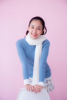 Happy beautiful young woman asian wearing scarf sitting on living room pastel color tone.