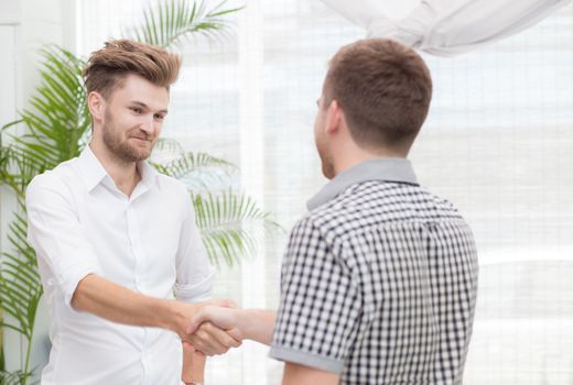 Two business colleagues handshake during meeting.