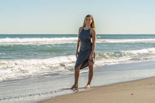 A gorgeous young blonde female enjoys a day at the beach alone