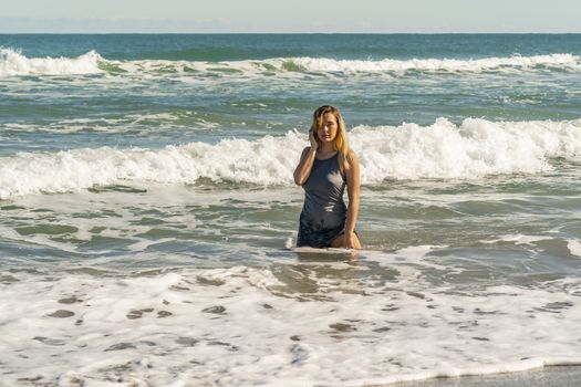 A gorgeous young blonde female enjoys a day at the beach alone