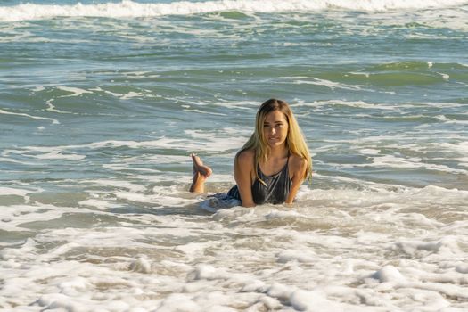 A gorgeous young blonde female enjoys a day at the beach alone