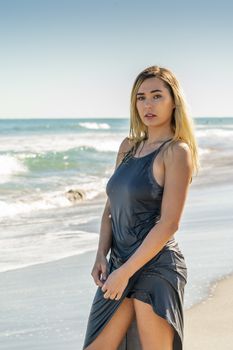 A gorgeous young blonde female enjoys a day at the beach alone
