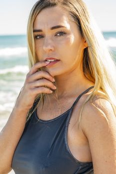 A gorgeous young blonde female enjoys a day at the beach alone