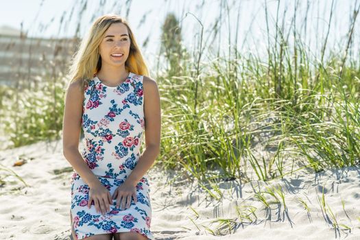 A gorgeous young blonde female enjoys a day at the beach alone