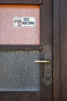 Dogs welcome sign on an old wooden door