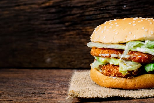 Hamburger a chicken on a wooden background