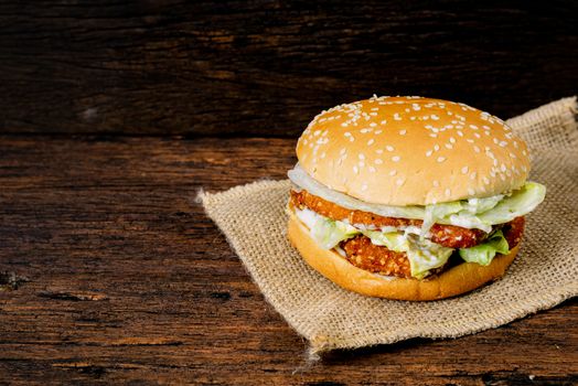 Hamburger a chicken on a wooden background