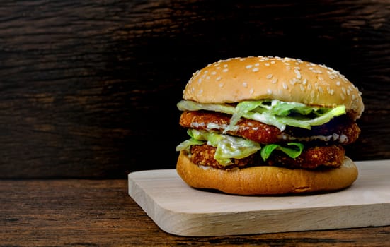 Hamburger a chicken on a wooden background