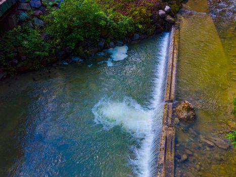 drone shot out in nature of river, bridge and green trees. Höllgrotte Switzerland