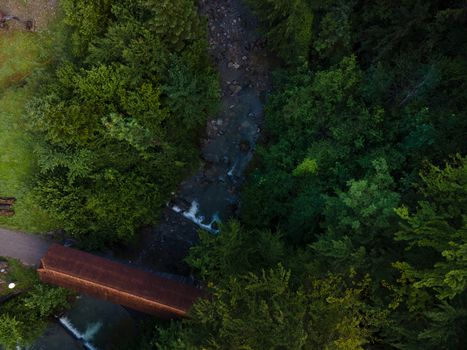 drone shot out in nature of river, bridge and green trees. Höllgrotte Switzerland