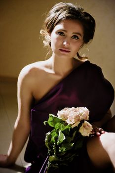 model girl in a blue dress in an art workshop with brushes, a palette and paintings