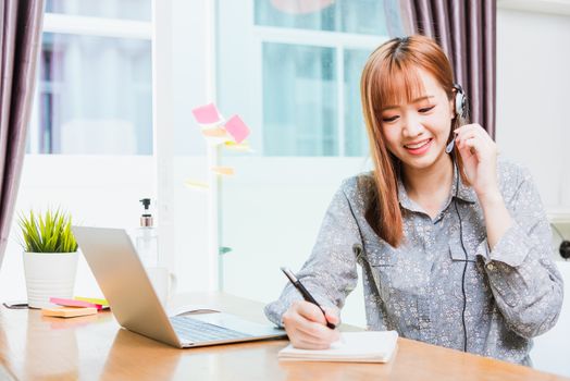 Work from home concept, Happy Asian beautiful young business woman wearing headphone call online conference video call meeting for discussion talking with boos and team together by laptop computer