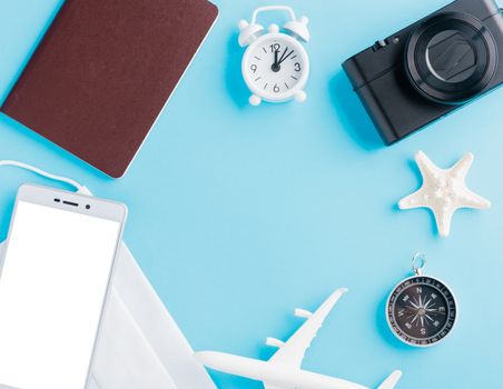 World Tourism Day, Top view of minimal model plane, airplane, starfish, compass, smartphone blank screen and face mask isolated on blue background, accessory flight holiday under coronavirus concept