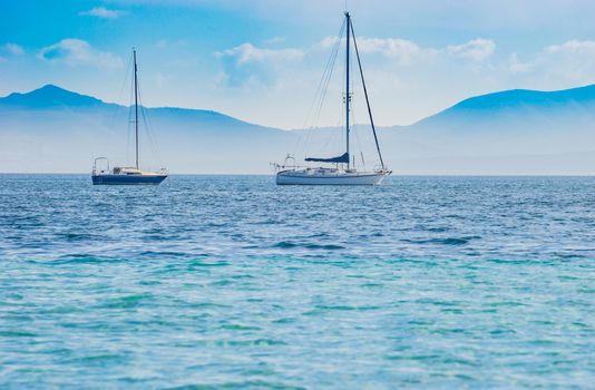 Idyllic view of luxury sailing yachts at bay with beautiful seascape scenery
