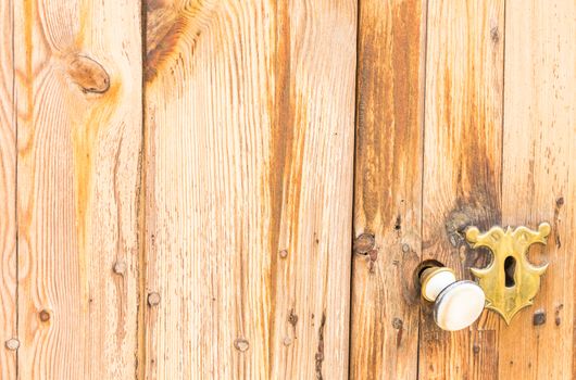 Closeup of an old keyhole and door knob of vintage wooden entrance front door
