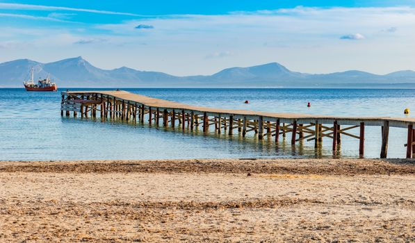 Idyllic view of the pier at the bay of Alcudia on Majorca, Spain Balearic islands