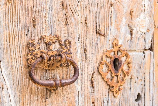 Closeup of an old door knocker and keyhole of vintage wooden entrance front door