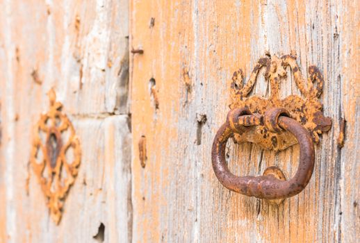 Closeup of an old door knocker of vintage wooden entrance front door
