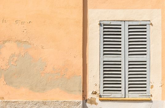 Detail view of wooden window shutters and wall