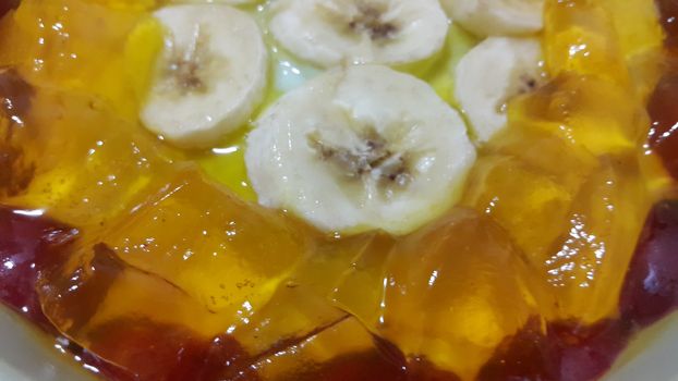 Creamy tasty sweet custard with banana pieces layered on surface. A close up top view of home made custard, a dairy products for dessert after meal.