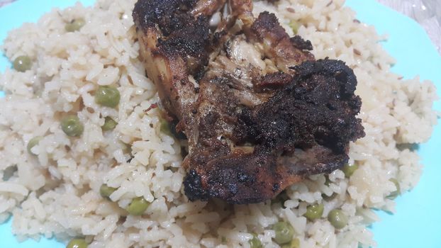 Fried, grilled chicken pieces with marinated spices on white thai rice. Tasty delicious fried chicken barbecue