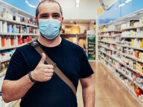 man in medical mask shopping at supermarket with thumb up