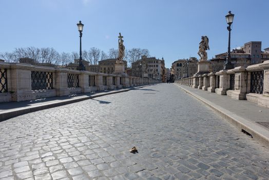 Rome, Italy - 12 March 2020: the popular tourist spot of the Sant Angelo bridge is now deserted, a rare sight in Rome, Italy. Today, the Italian government decreed a nationwide lockdown, with travel and movement bans, closing of shops, bar and restaurants, and emergency health measures following the CoVid-19 epidemic.